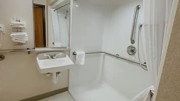 Un baño moderno con cabina de ducha, lavabo y espejo.