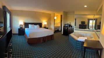 Une chambre d’hôtel avec un grand lit, une salle de bain séparée avec une baignoire, un bureau et une télévision.