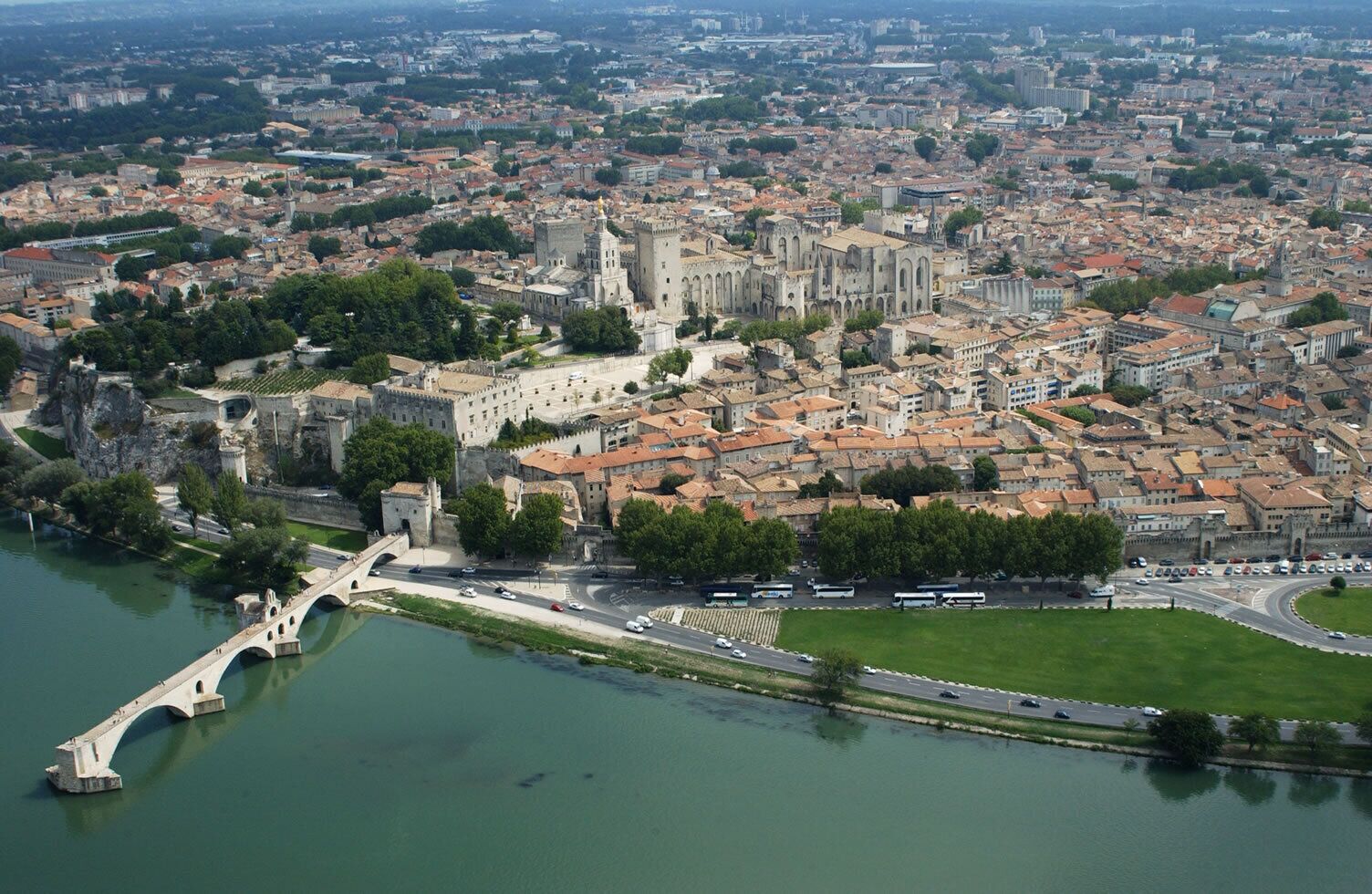 Une vue aérienne d’une ville historique, avec un château imposant, une rivière et un pont.