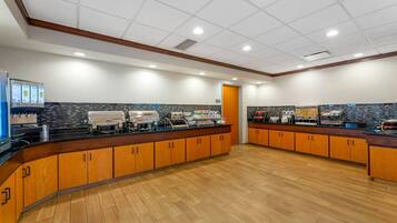 A spacious kitchen area with wooden cabinets, a central island, and various appliances.