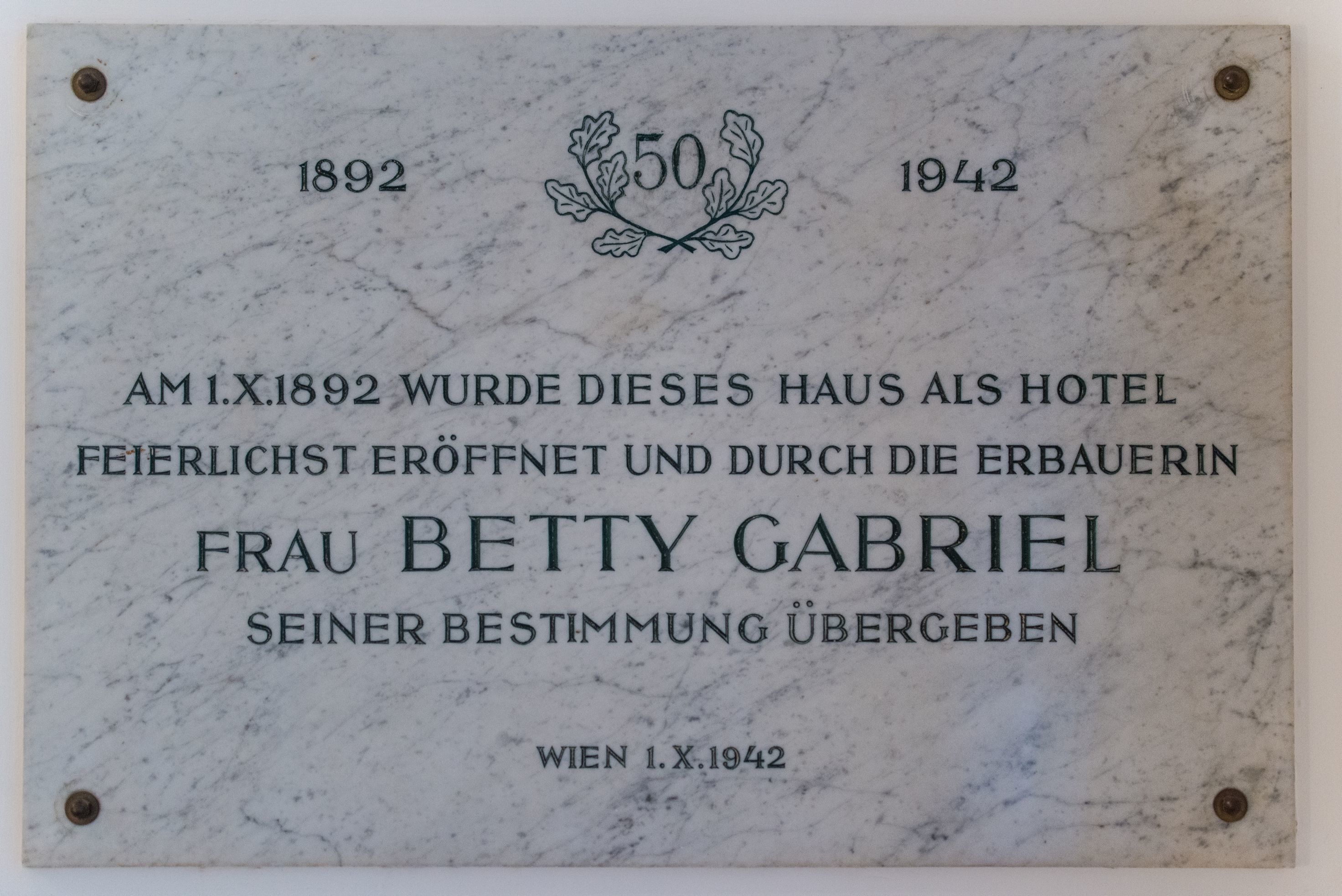 A commemorative plaque marking the 50th anniversary of a hotel, established in 1892 by Frau Betty Gabriel.