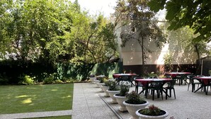 A courtyard with outdoor seating, potted plants, and a well-maintained lawn. - Garten - & Kunsthotels Gabriel (Vienna)