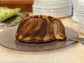 Um bolo bundt num prato com uma faca ao lado.