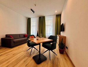 Superior Apartment | Living area | 100-cm LED TV with satellite channels, TV, first-run movies - Lucia Hotel (Vienna)