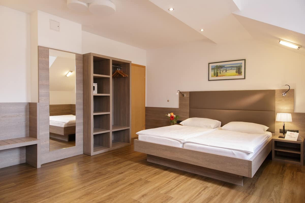 Ein modernes Schlafzimmer mit einem großen Bett, einem Einbauschrank und einem Nachttisch mit Lampe.