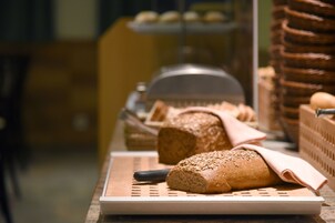 A bakery display with various breads and pastries.