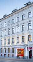 A hotel with a classic facade, multiple windows, and a prominent entrance with a red door.