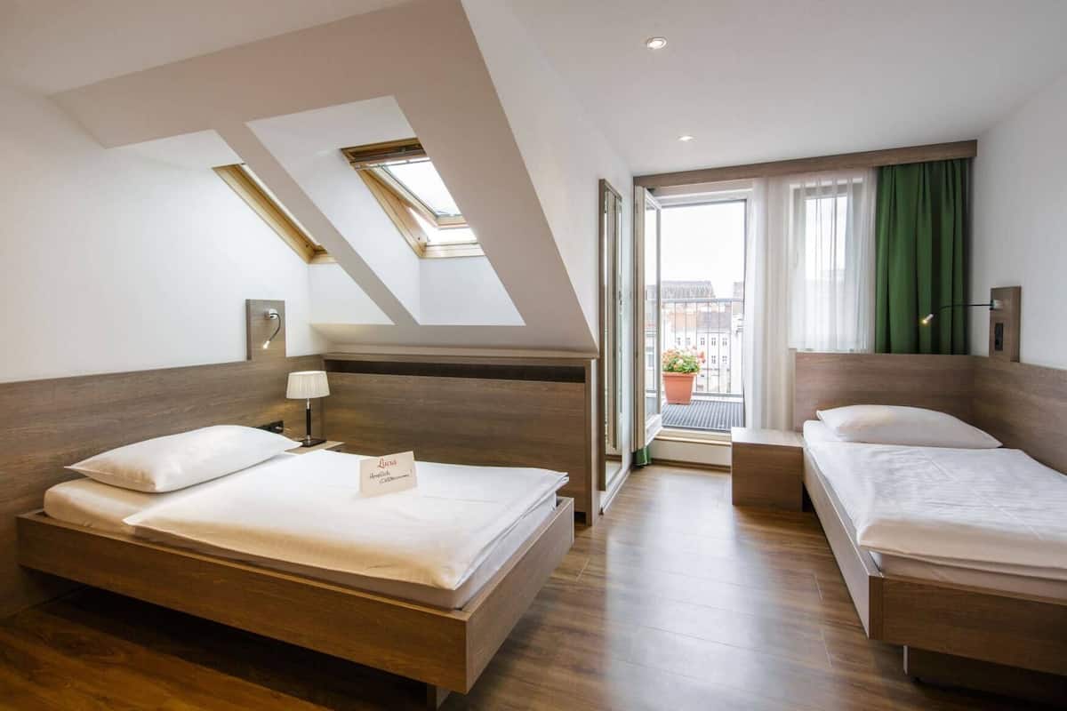 Ein Hotelzimmer mit zwei Betten, einem Oberlicht, einem Balkon mit Blick und einem Schild auf dem Bett.