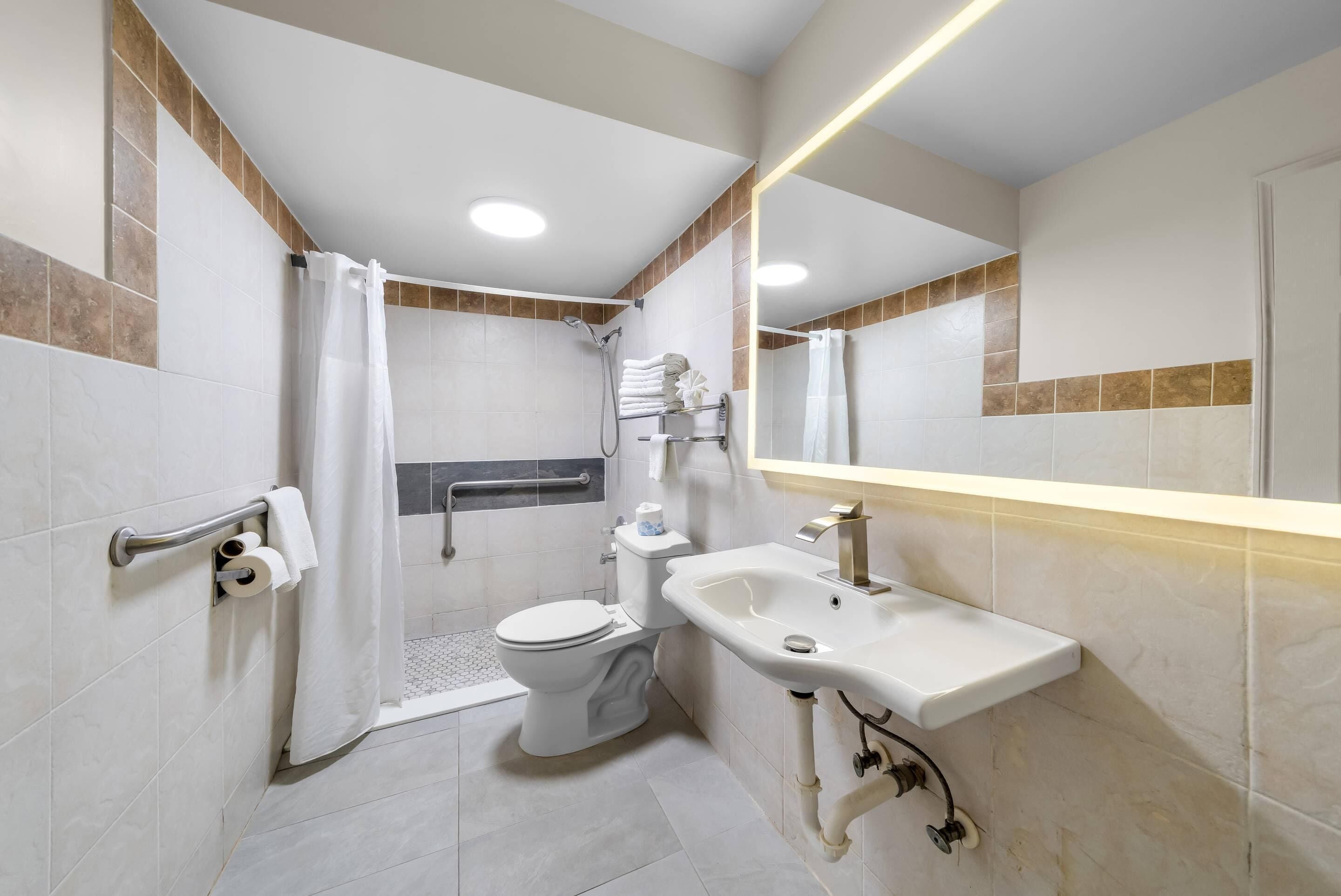 A modern bathroom with a shower, toilet, and sink.