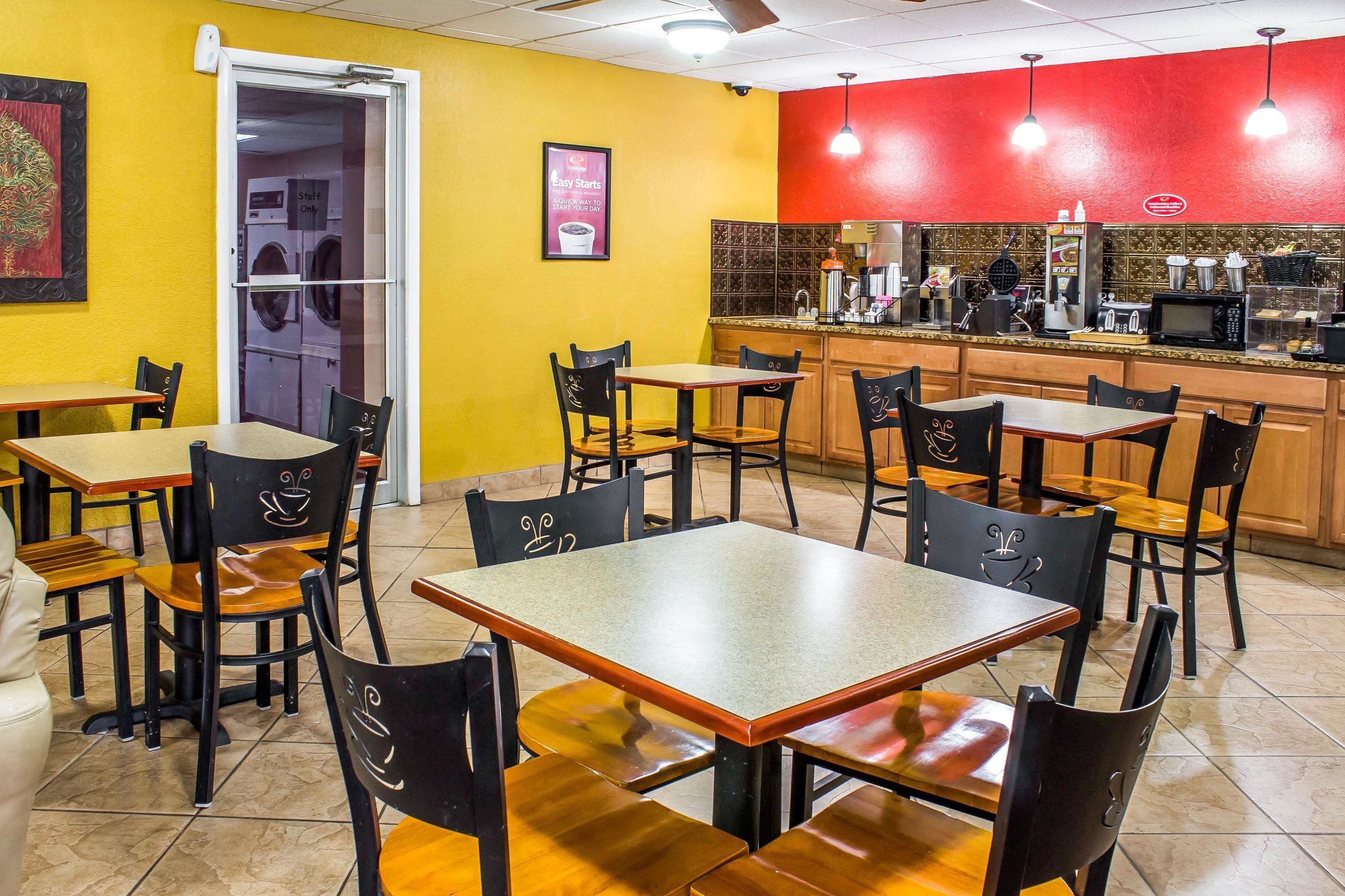 A restaurant with multiple tables and chairs, a kitchen area, and a door labeled "Staff Only".