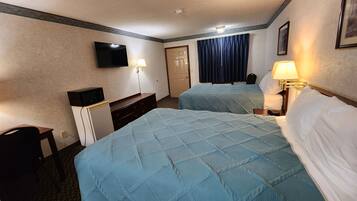 Une chambre d’hôtel avec deux lits, une télévision, un bureau et une chaise.