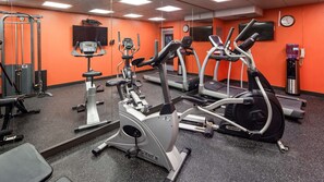 A gym with various exercise equipment, including treadmills and stationary bikes, and a water dispenser. - Best Western Paramus Hotel & Suites (Paramus)
