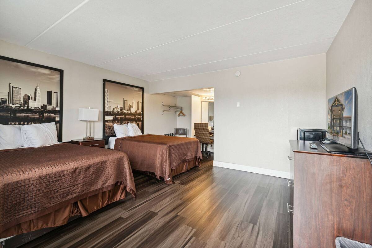 Een hotelkamer met twee bedden, een bureau, een stoel en een televisie.