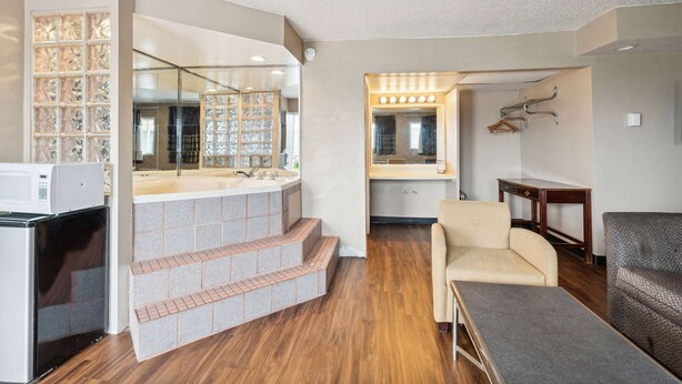 A modern bathroom with a large mirror, vanity, and a built-in shower. - Super 8 by Wyndham Millbury/Toledo (Millbury)