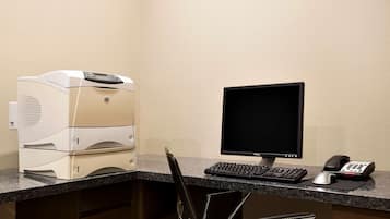 Ein Schreibtisch mit Drucker, Computermonitor, Tastatur, Maus und Telefon.