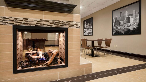 Eine moderne Lobby mit Kamin, Essbereich und Stadtbild-Mural.