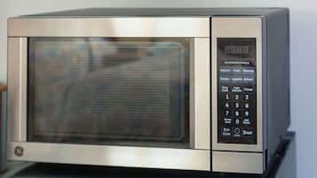 A stainless steel microwave with a digital display and a keypad.