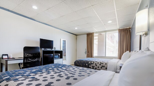 A hotel room with two beds, a desk with a computer, a TV, and a window with curtains. - Edyn Hotel By Townhouse Wytheville US 52 (Wytheville)