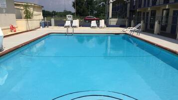 Relax by the pool with comfortable lounge chairs and a lifebuoy nearby.