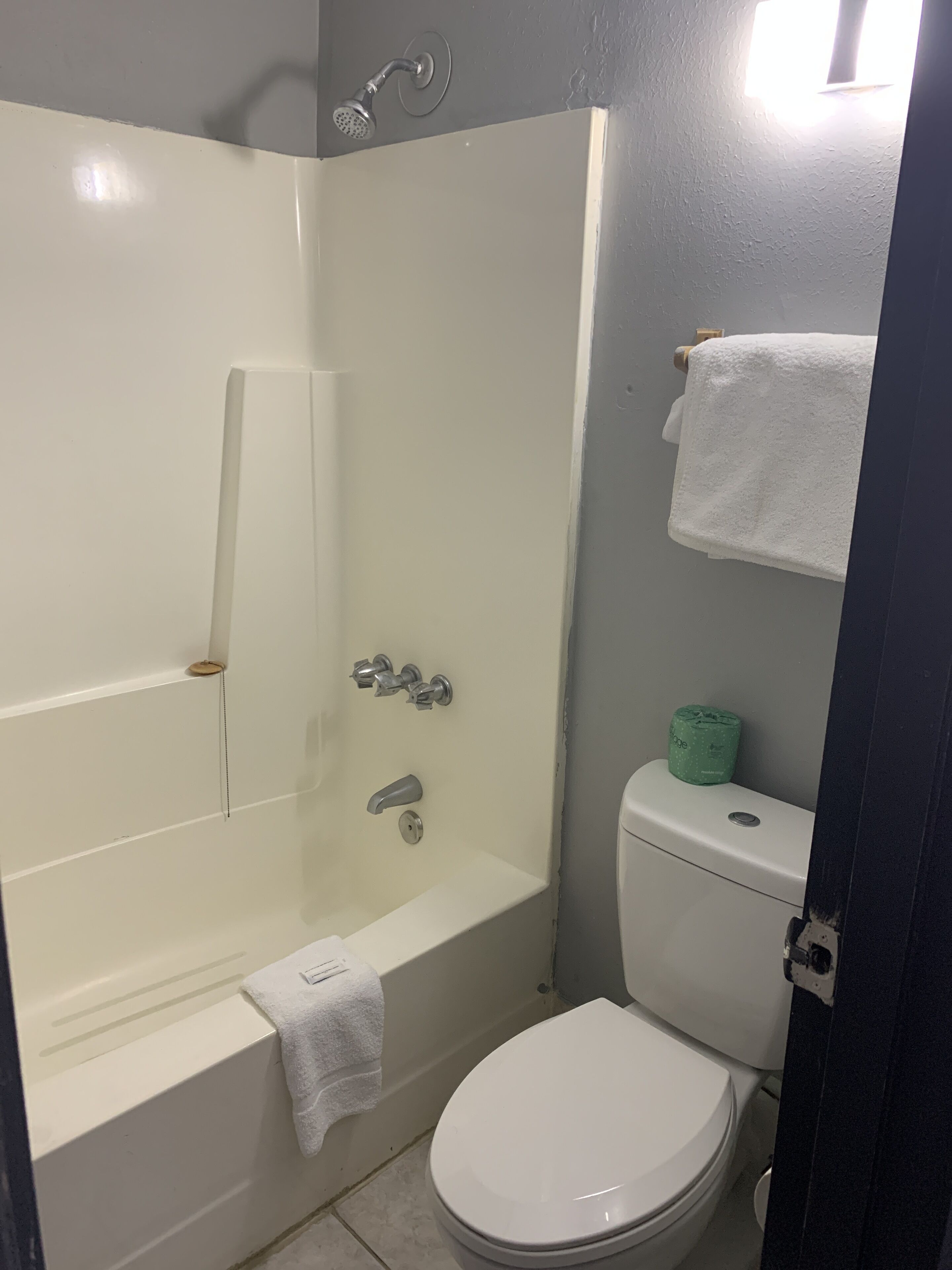 Un baño con bañera, inodoro y toallero.