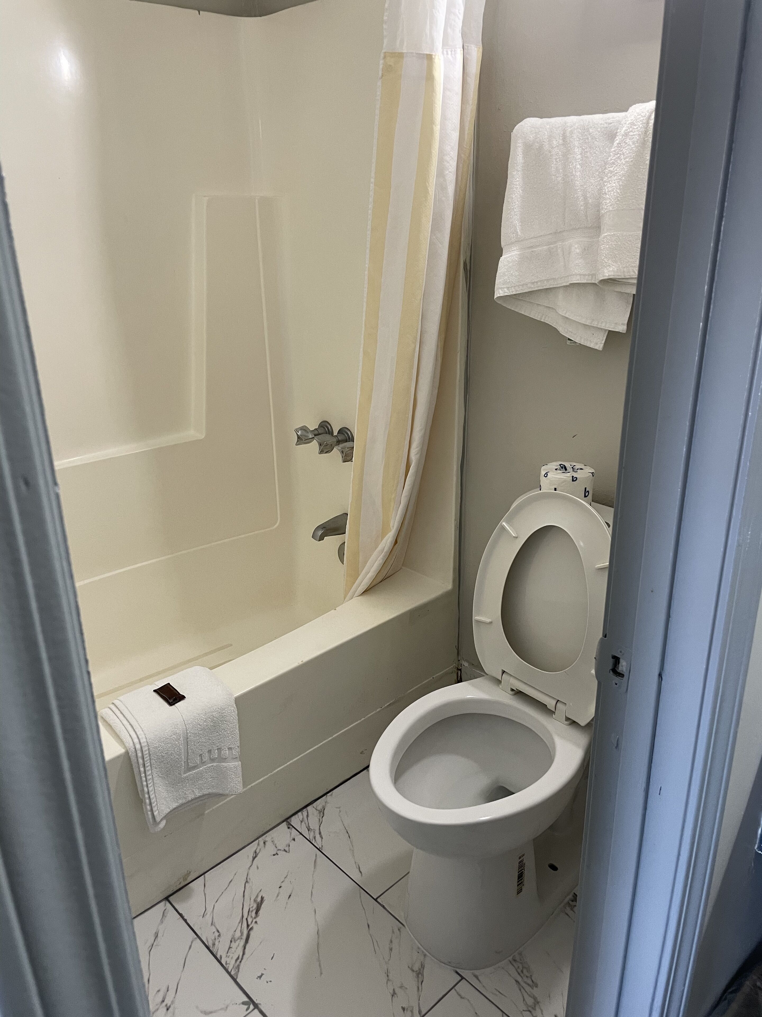 Un baño con bañera, inodoro y cortina de ducha.