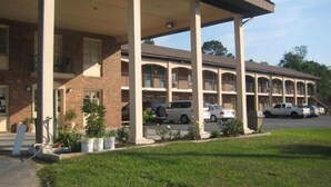 Un hôtel à plusieurs étages, doté d’une façade en briques, de nombreux balcons et d’un parking couvert.
