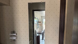 Une salle de bain avec un miroir, un porte-serviettes et un plancher en bois.