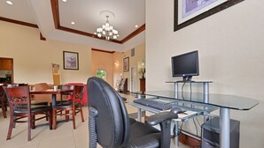 A modern office space with a glass desk, black office chair, and a desktop computer. - Quality Inn & Suites Cartersville North (White)