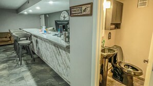 A kitchen with a marble countertop, a clock, and a sign indicating a restroom. - The No Wake Inn - Osage Beach (Osage Beach)