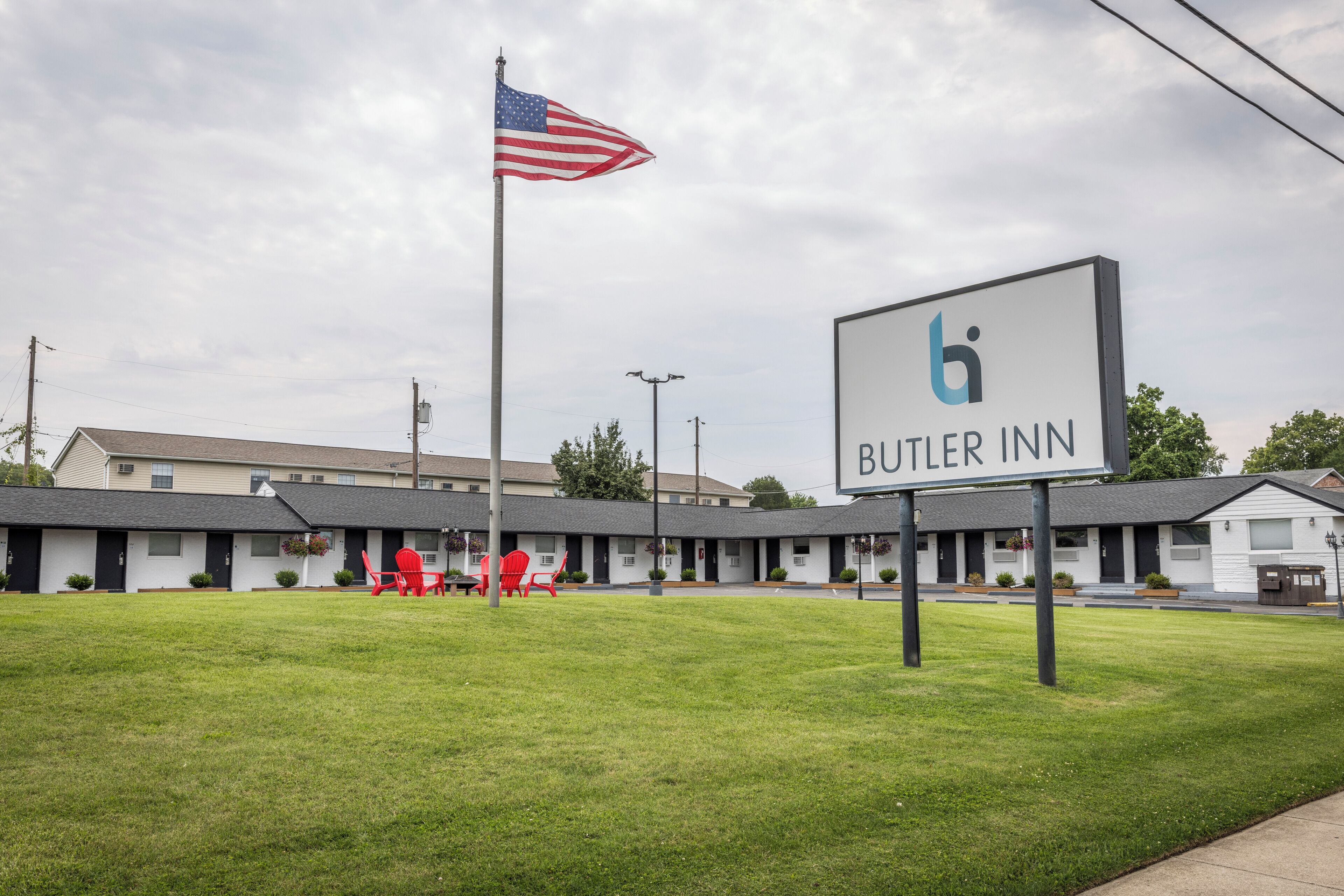 Un motel con un cartello che recita 'Butler Inn' e un'asta con la bandiera americana.