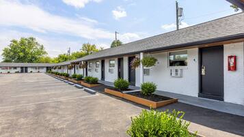 Un motel con una fila de habitaciones, cada una con ventana y puerta.