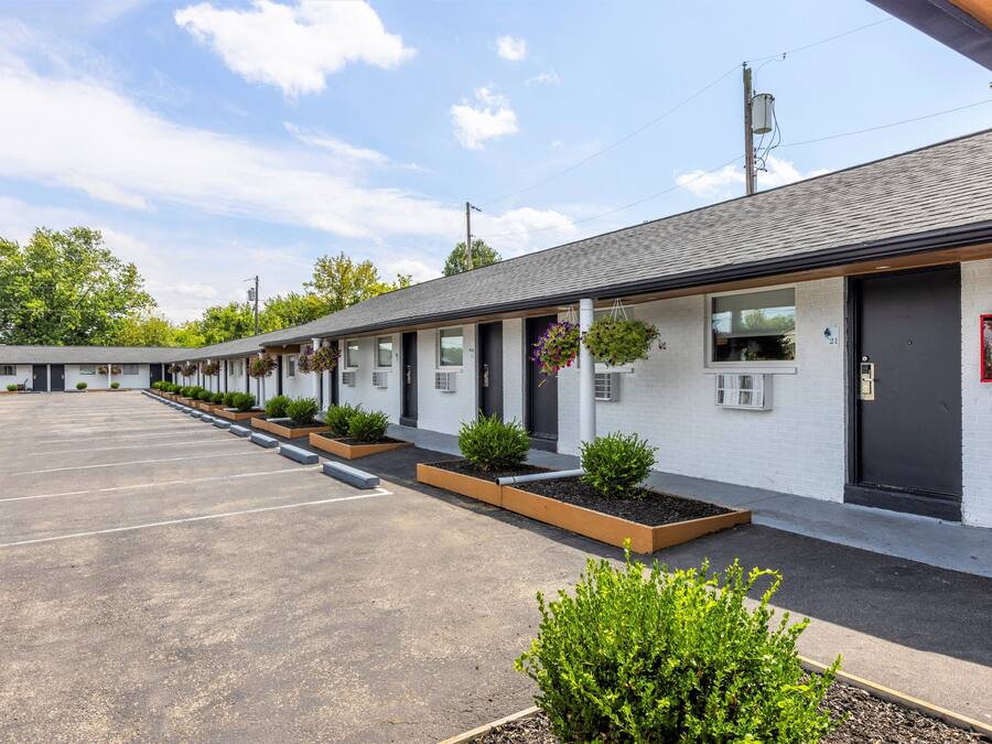 Un motel con una fila de habitaciones, cada una con ventana y puerta.