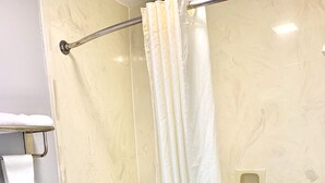 A bathroom with a toilet, bathtub, and shower curtain. - Scottish Inns Westcott Street (Houston)