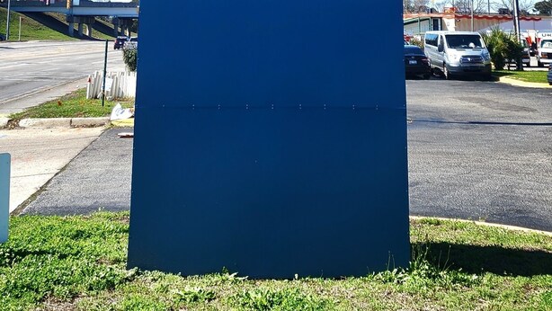 A blue sign with the text "Suburban Studios Extended Stay by Choice Hotels".
