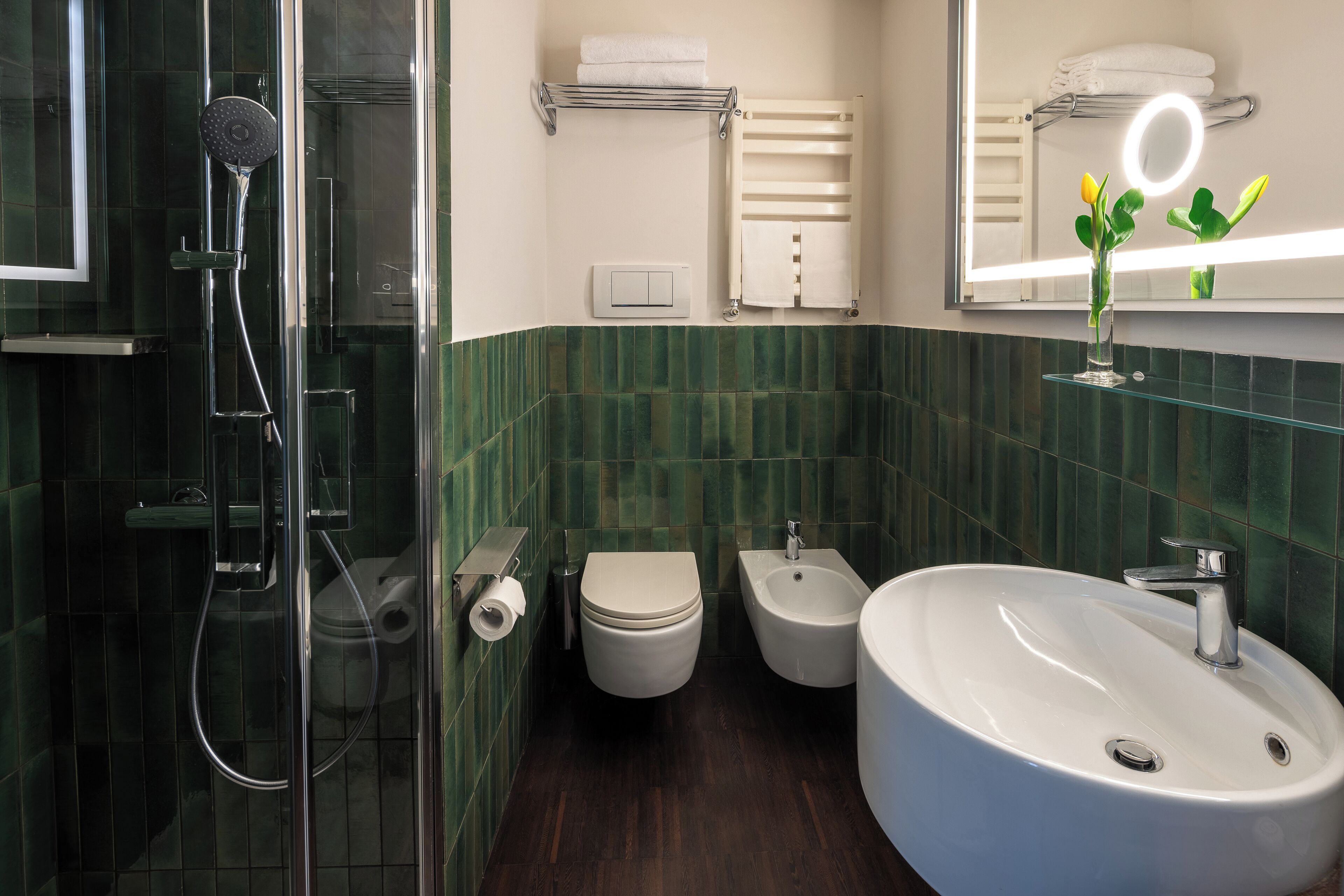 Une salle de bain moderne avec une douche à parois de verre, des toilettes, un bidet et un grand lavabo.