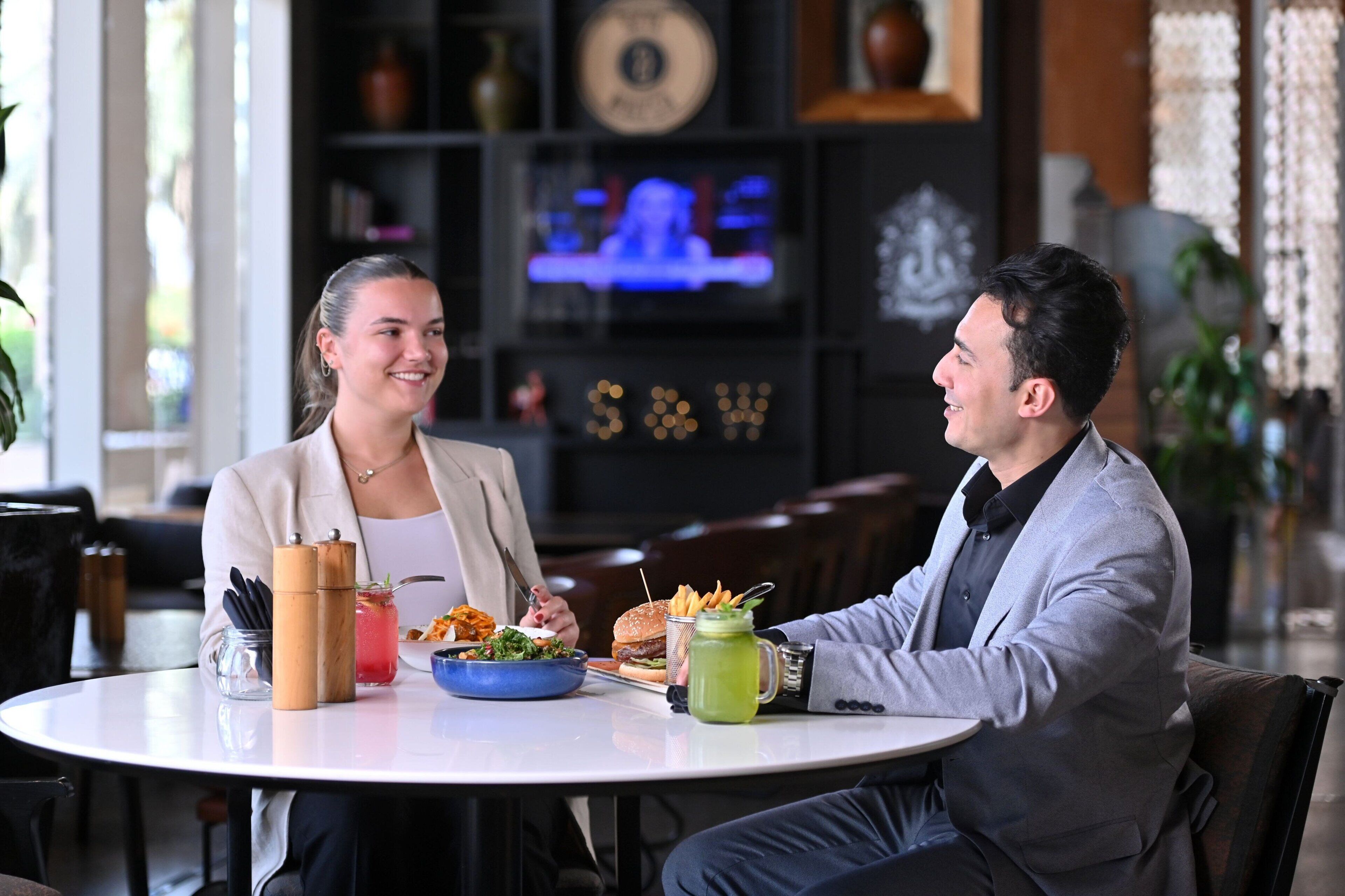 A restaurant setting with a round table, a menu, and a television in the background.