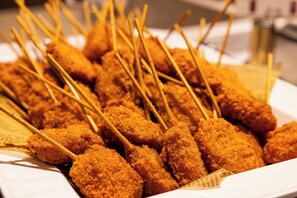 A plate of fried food items with skewers. - Hotel Keihan Universal Tower (Osaka)