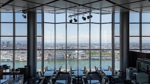 Un comedor moderno con ventanas amplias que ofrecen vista a la ciudad.