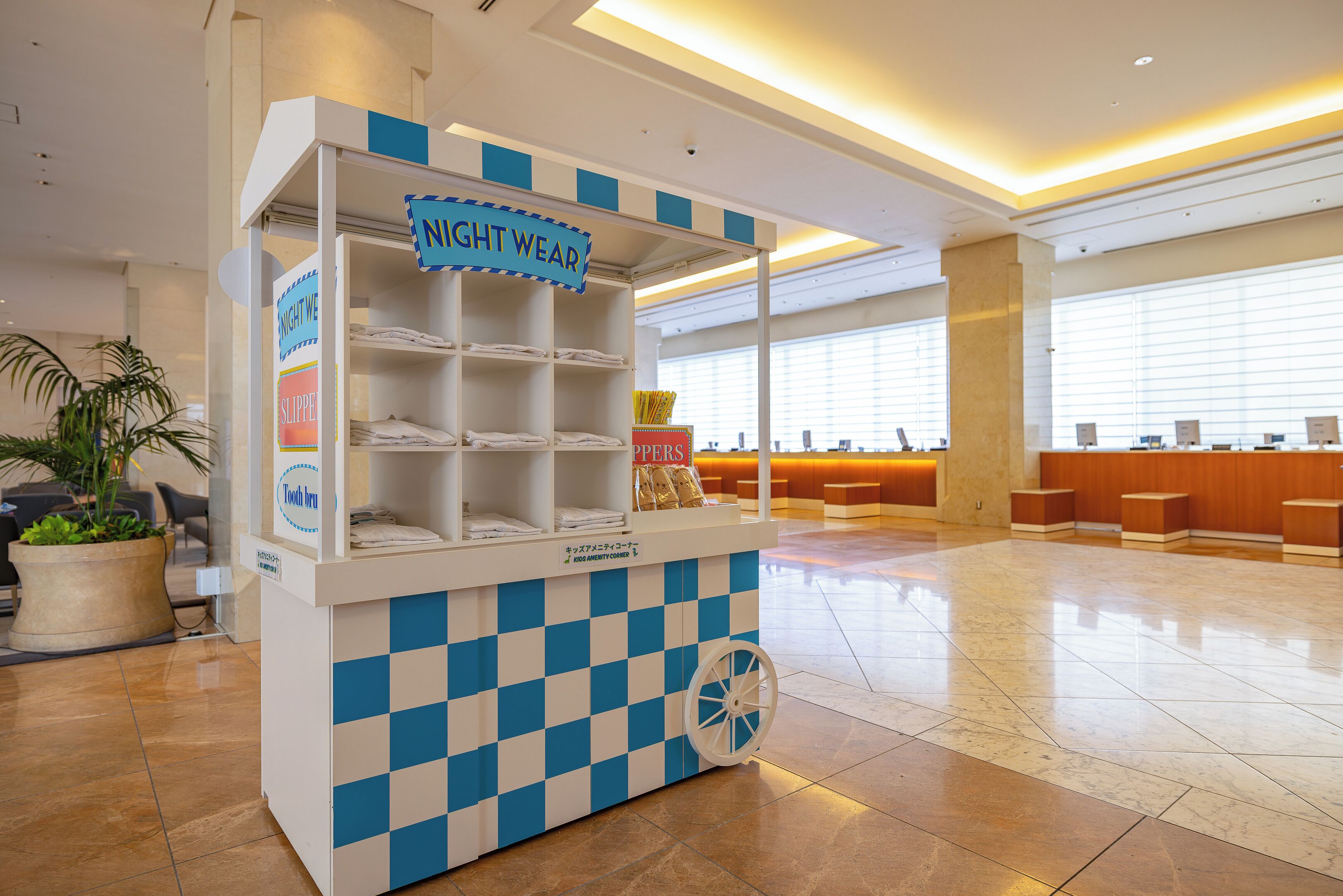 A check-in counter with a sign reading "Night Wear" and a sign for "Slippers".