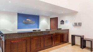 Un comptoir d’accueil avec une enseigne bleue indiquant « Baymont Inn & Suites ».