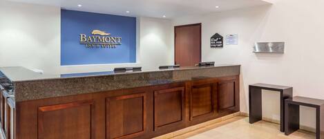 Un mostrador de recepción con un letrero azul que dice "Baymont Inn & Suites".