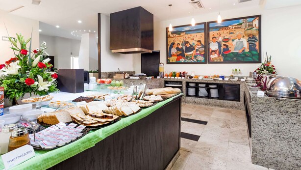 Un buffet proposant une variété de plats et agrémenté d’une composition florale décorative.
