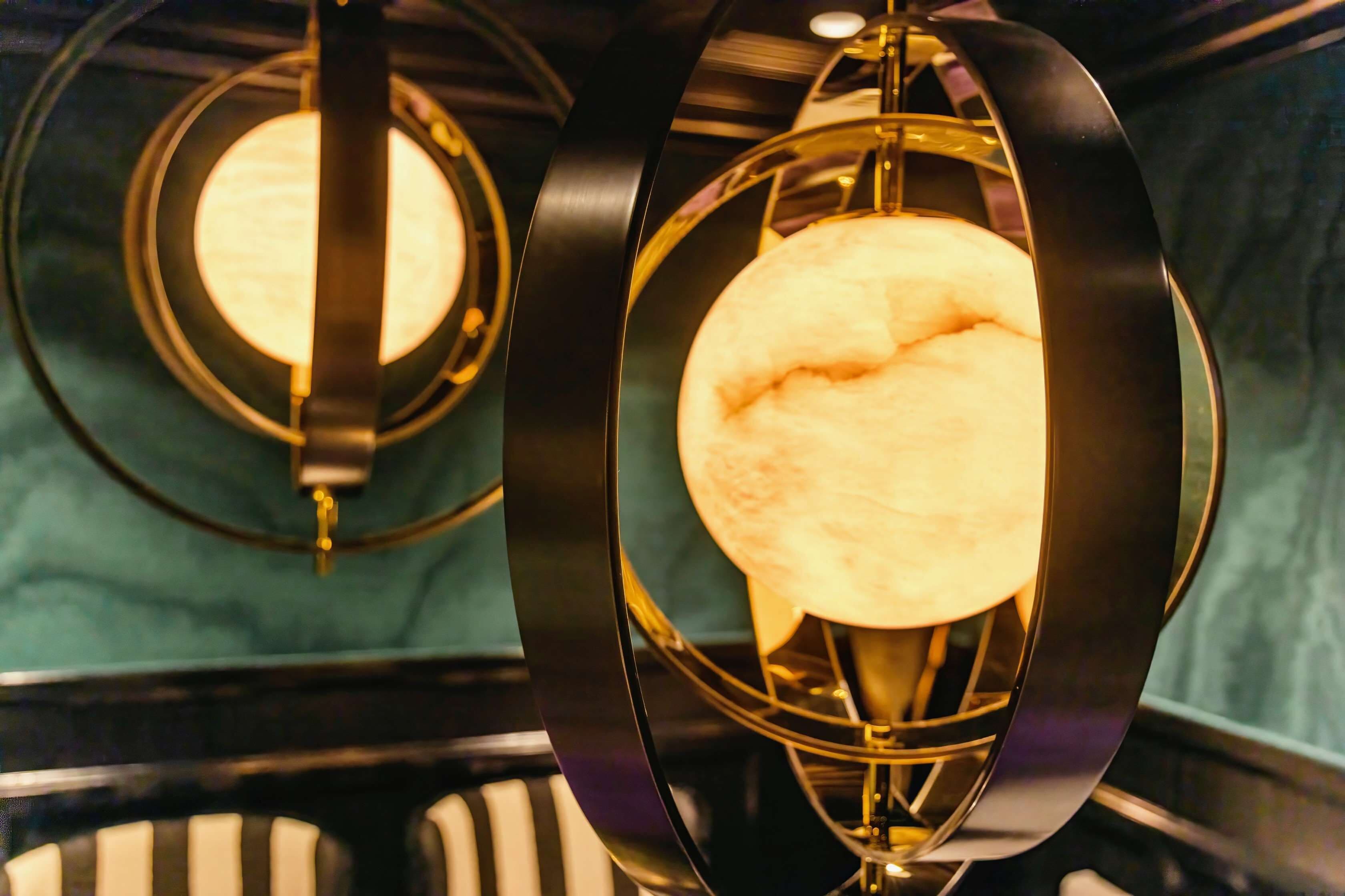 A close-up of a modern chandelier with a spherical light fixture.