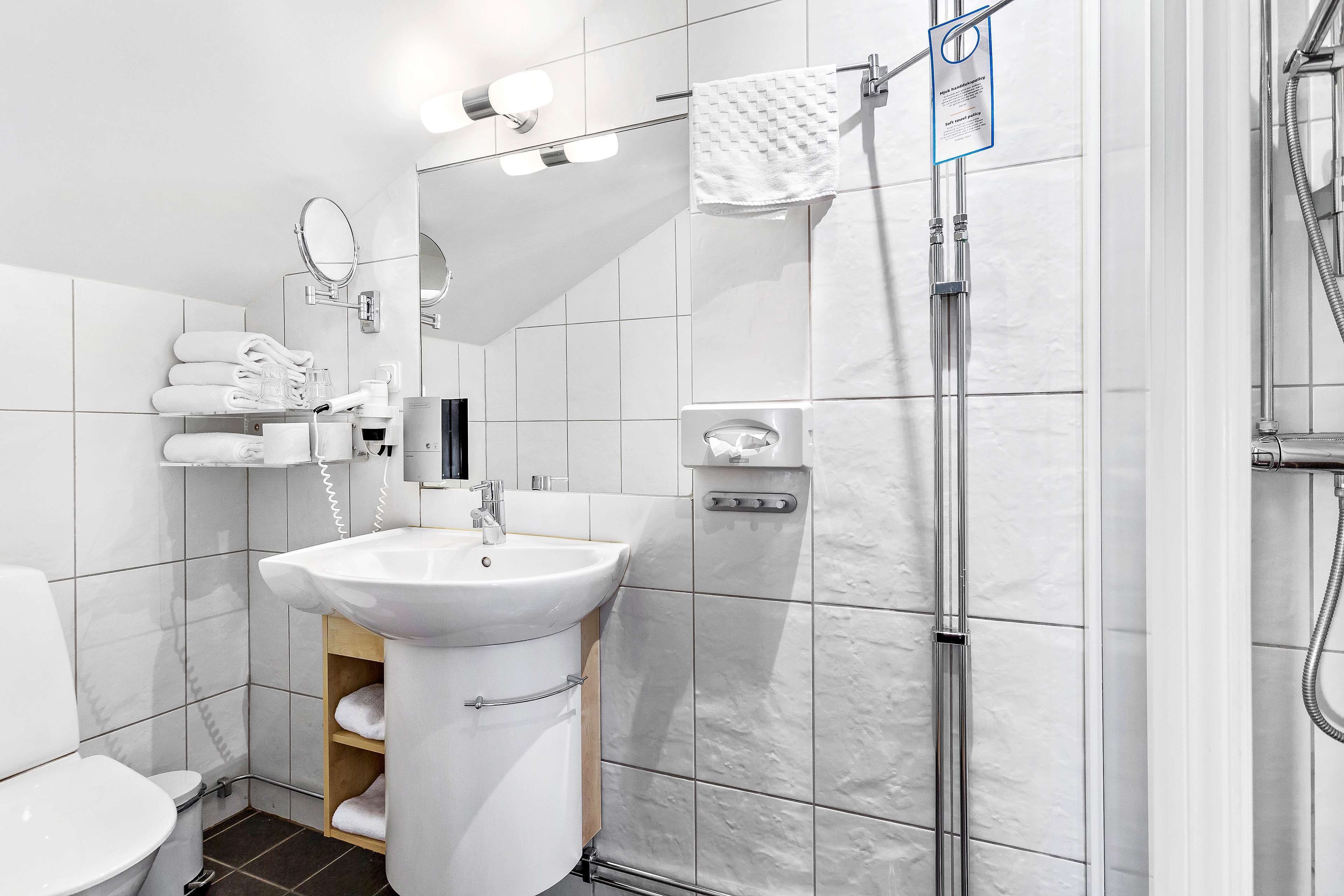 Ein modernes Badezimmer mit Waschbecken, Spiegel und Handtuchhalter.