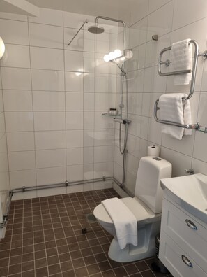 A modern bathroom with a shower, toilet, and sink.