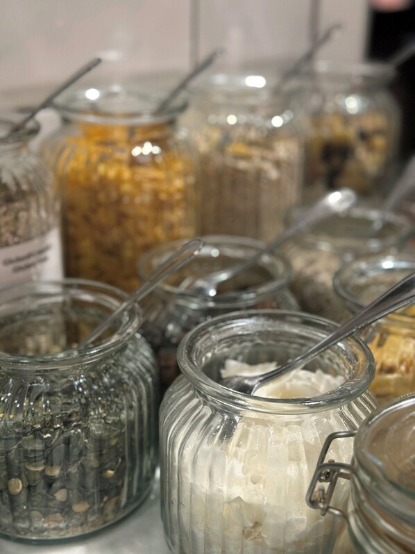 A collection of glass jars with metal lids, some containing white substances, likely for storage or serving.