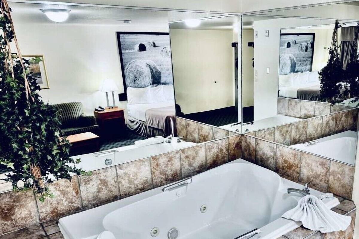 Un bany modern amb una banyera gran, un lavabo doble i un mirall ampli.