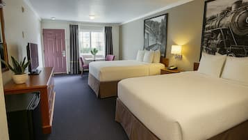 A hotel room with two beds, a desk with a TV, a chair, a window with curtains, and a painting on the wall.