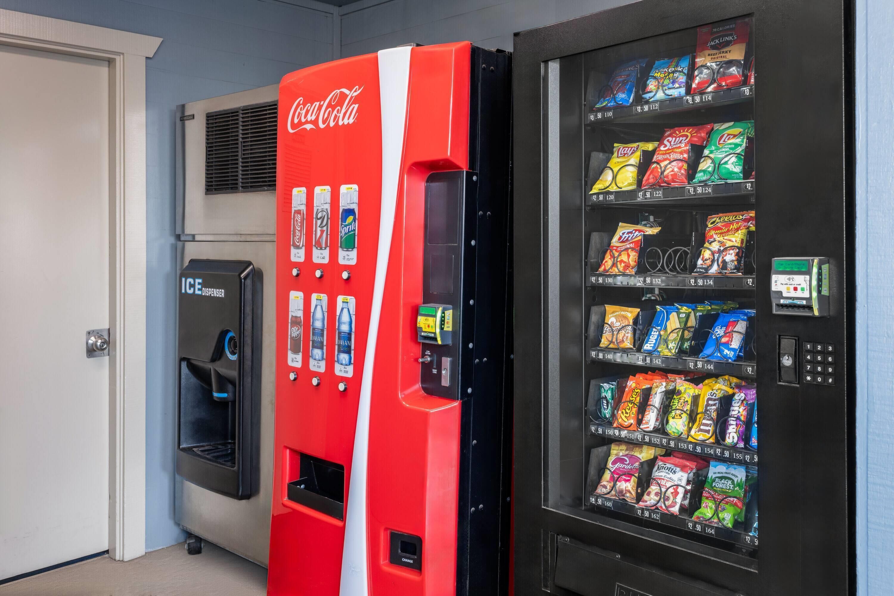 Máquina expendedora con Coca-Cola y una variedad de bocadillos.