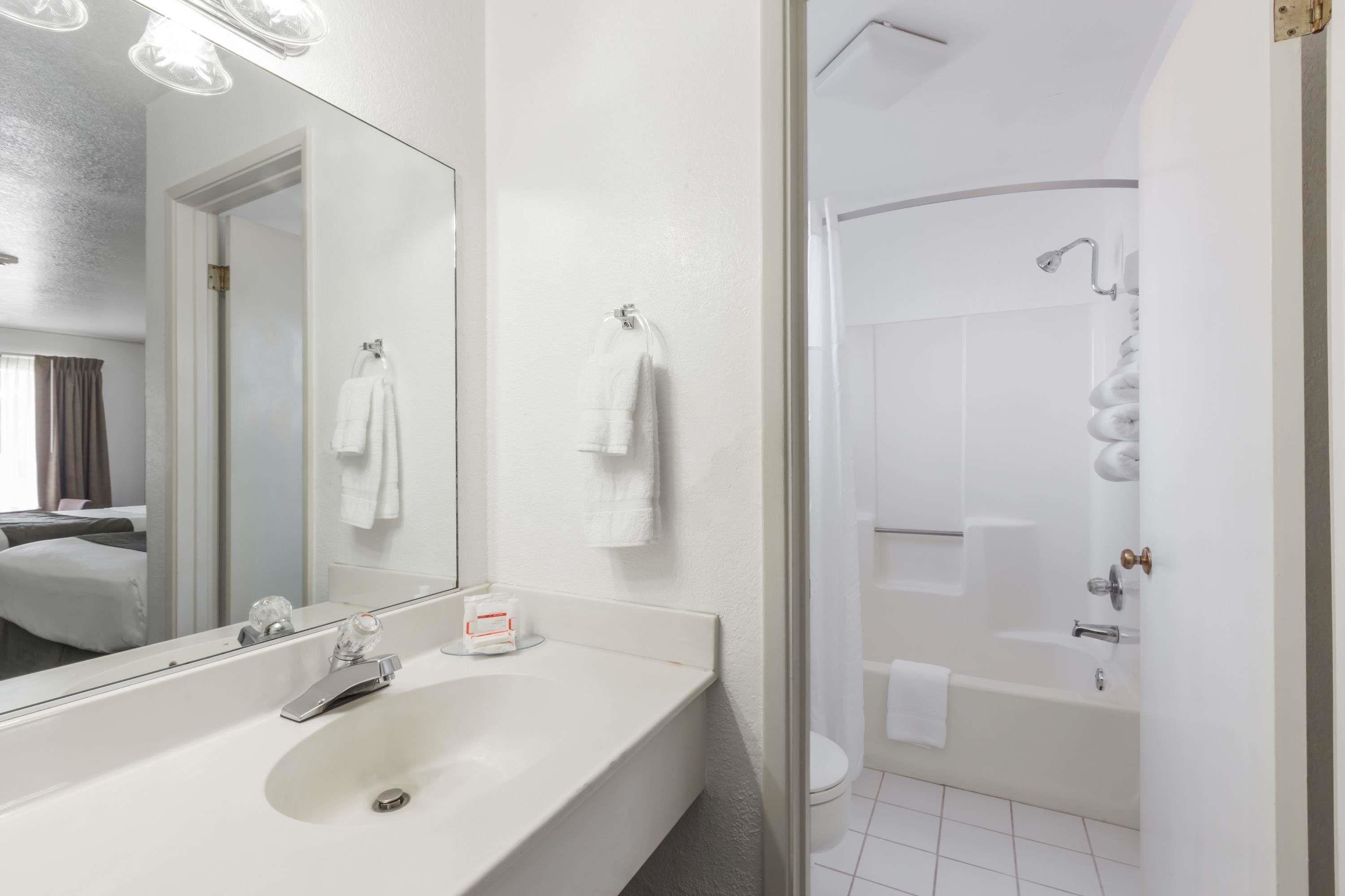 Een moderne badkamer met een grote spiegel, een wastafel en een douchecabine.
